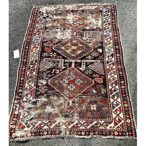 1587 - A Caucasian Kazak old rug, with three hooked medallions, many holes and very worn, 163cm x 110cm app... 