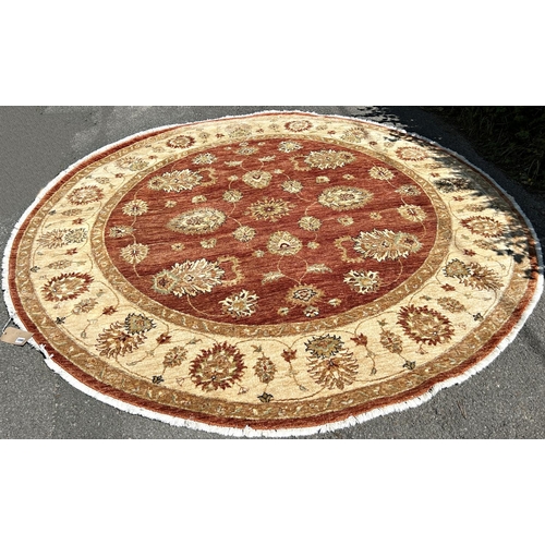 1590 - A circular Zeigler carpet with a central brown circular panel with an all over floral pattern, and a... 