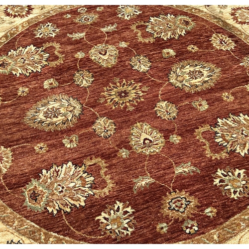 1590 - A circular Zeigler carpet with a central brown circular panel with an all over floral pattern, and a... 