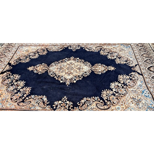 1597 - A large Persian Kerman type carpet with an extended lozenge medallion on a predominantly blue ground... 