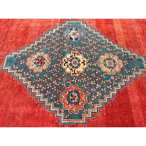 1601 - A modern Kazak design carpet in wool with a central stepped medallion decorated with flowers on a pr... 