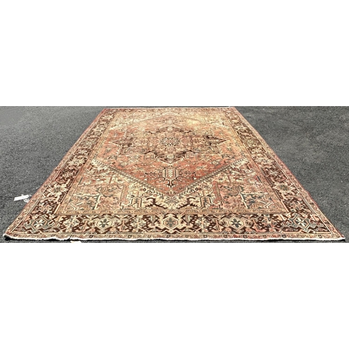 1602 - A large faded and slightly worn old Kazak carpet with a central star shaped medallion in pale pinks ... 