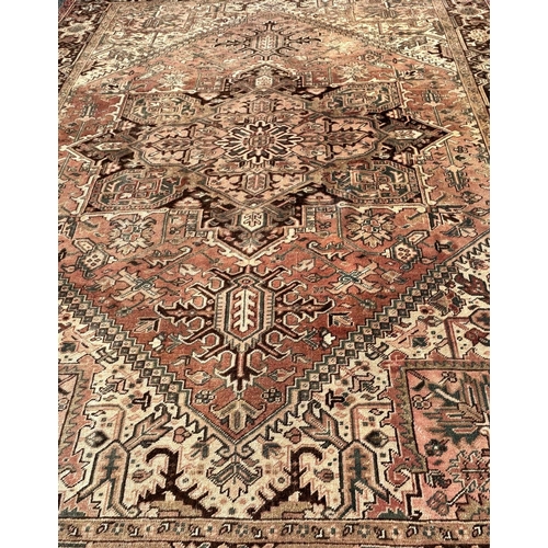 1602 - A large faded and slightly worn old Kazak carpet with a central star shaped medallion in pale pinks ... 