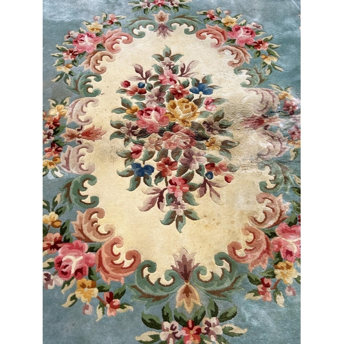 1612 - A large wool 18th century Aubusson style carpet with a central cluster of flowers on a green ground ... 