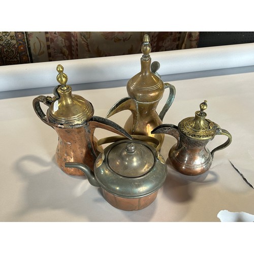 1529 - Three graduated similar Arabic coffee pots, a copper kettle, a pair of brass candlesticks and a thir... 