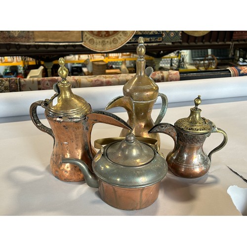 1529 - Three graduated similar Arabic coffee pots, a copper kettle, a pair of brass candlesticks and a thir... 