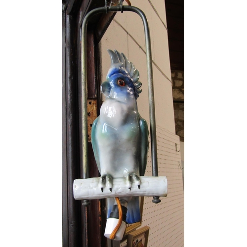 1070 - Continental porcelain ceiling light in the form of a parakeet perched on a branch suspended within m... 