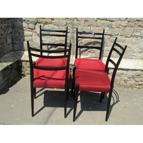 2153 - A set of six G-Plan dining chairs with ebonised frames and red upholstered seats