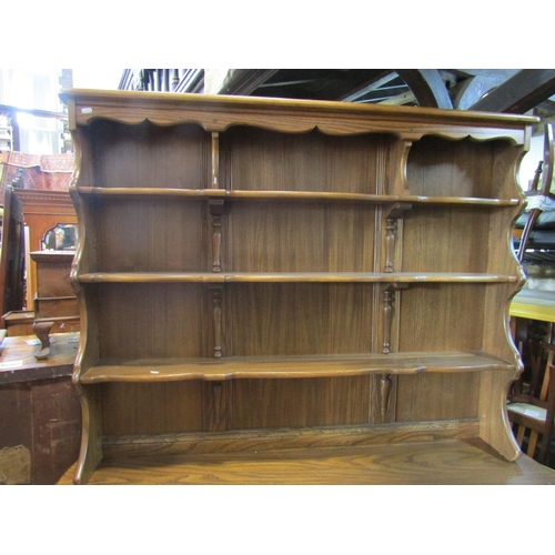 2197 - An Ercol oak dresser, the base enclosed by three panelled doors and three drawers, the plate rack wi... 