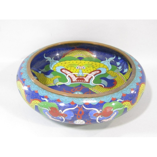 An early 20th century, Chinese cloisonné bowl with a central angry dragon in bold colours, with further dragons to the exterior, signed to the base, (as found big dent) 25cm diam.