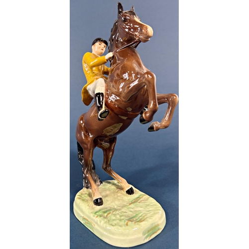 1097 - A Beswick figure of a rearing horse and huntsman in a Berkeley Hunt colourway jacket