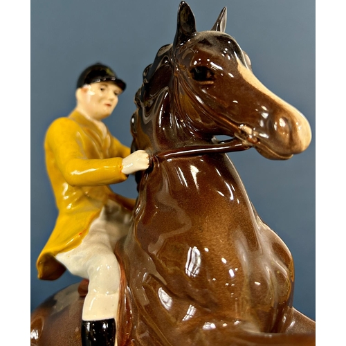 1097 - A Beswick figure of a rearing horse and huntsman in a Berkeley Hunt colourway jacket