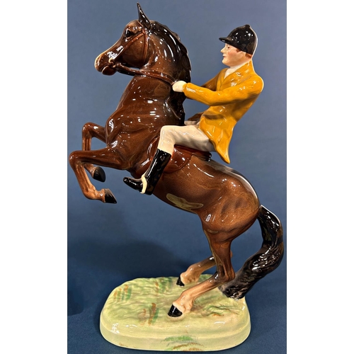 1097 - A Beswick figure of a rearing horse and huntsman in a Berkeley Hunt colourway jacket