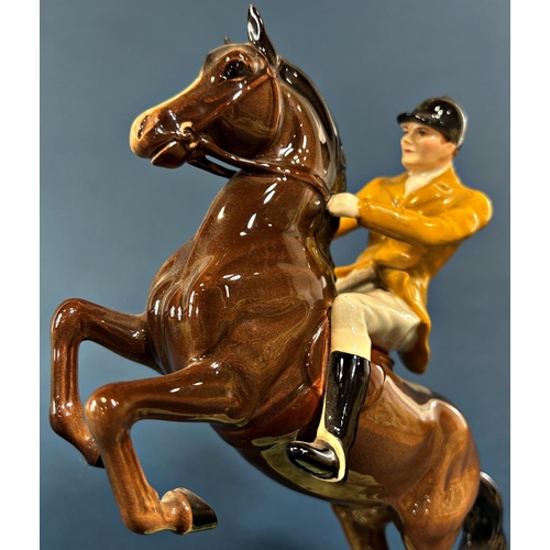 1097 - A Beswick figure of a rearing horse and huntsman in a Berkeley Hunt colourway jacket