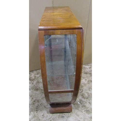 2302 - 1950s walnut veneered display cabinet, with shaped outline and glazed panelled sliding doors