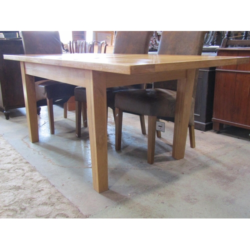 2305 - A contemporary oak kitchen table, the panelled top raised on four square cut supports, with two addi... 