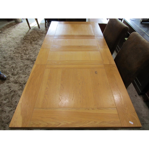 2305 - A contemporary oak kitchen table, the panelled top raised on four square cut supports, with two addi... 