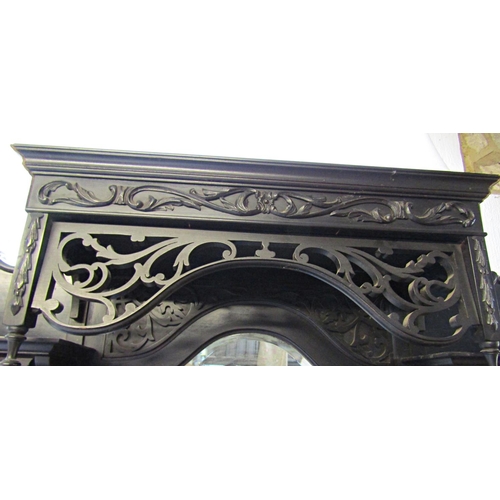 2347 - An Edwardian ebonised chiffonier of full height, the lower section enclosed by a series of doors and... 