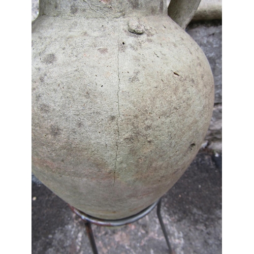 2067 - A small Mediterranean weathered buff coloured terracotta amphora, with moulded loop handles, raised ... 