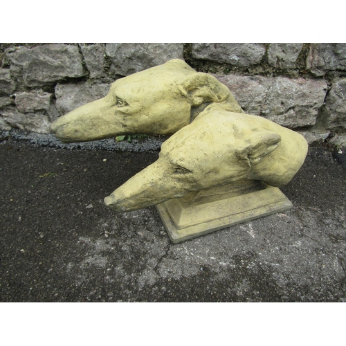 2071 - A buff coloured composition stone study of greyhound heads, of stepped form, set on a rectangular pl... 