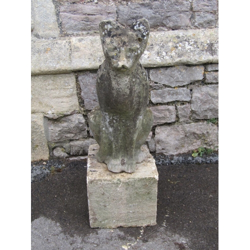 2083 - A weathered garden ornament in the form of a seated cat, raised on loose stone block pedestal, 78cm ... 