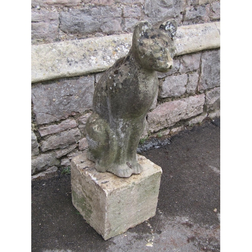 2083 - A weathered garden ornament in the form of a seated cat, raised on loose stone block pedestal, 78cm ... 