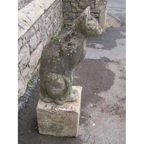 2083 - A weathered garden ornament in the form of a seated cat, raised on loose stone block pedestal, 78cm ... 