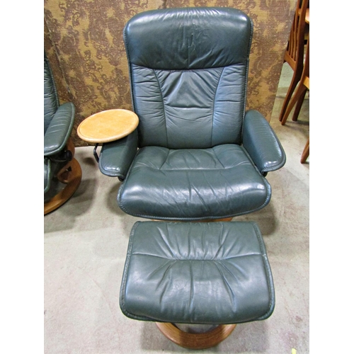 2169 - An Ekorness Stressless  swivel and adjustable lounge chair and matching stool with dark stitched sof... 