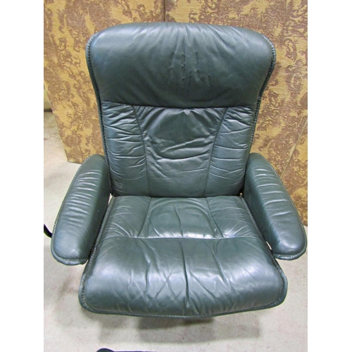 2170 - An Ekorness Stressless  swivel and adjustable lounge chair and matching stool with dark stitched sof... 