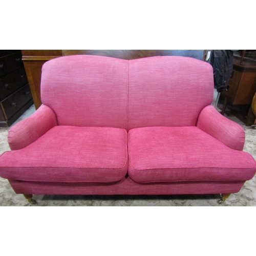 2344 - A Laura Ashley 'Howard' style two seat sofa in a cranberry coloured upholstery on turned supports, w... 