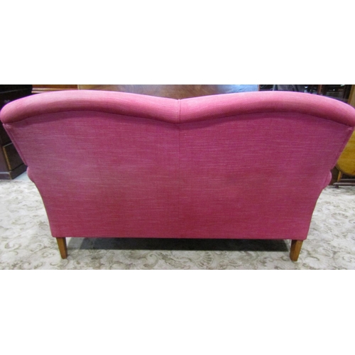 2344 - A Laura Ashley 'Howard' style two seat sofa in a cranberry coloured upholstery on turned supports, w... 