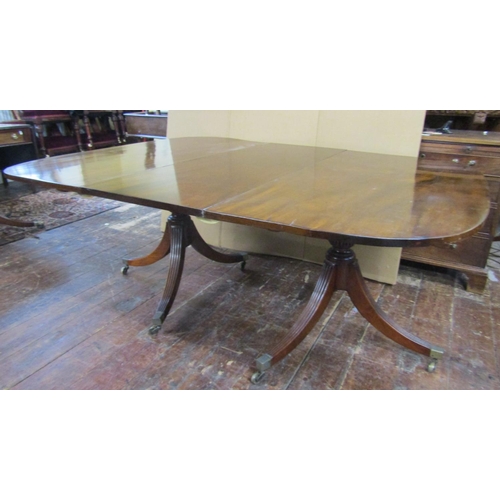 2617 - A Georgian style mahogany twin pillar extending dining table with single additional leaf, the sabre ... 