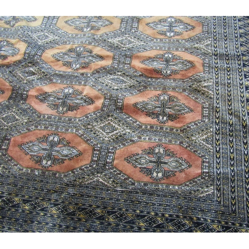 1670 - A Large Princess Bokhara Design Rug in faded burnt orange tones with an intricate dark blue border, ... 