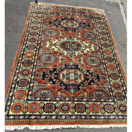 1674 - A Kazak Rug with three central diamonds in a field of burnt orange with repeating patterned border, ... 