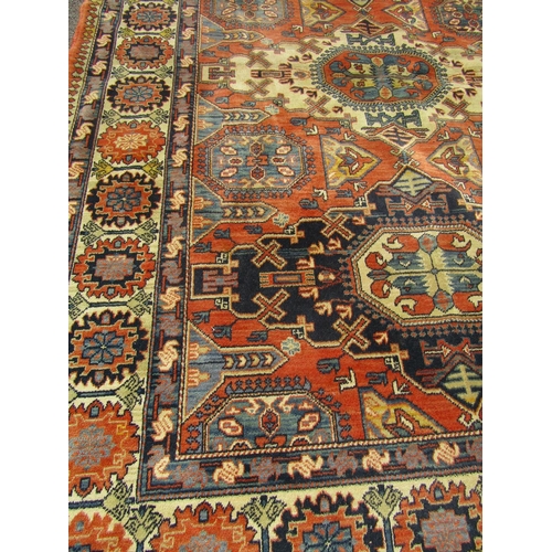 1674 - A Kazak Rug with three central diamonds in a field of burnt orange with repeating patterned border, ... 