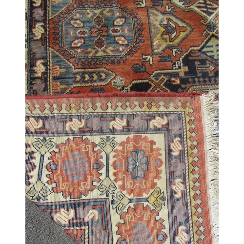 1674 - A Kazak Rug with three central diamonds in a field of burnt orange with repeating patterned border, ... 