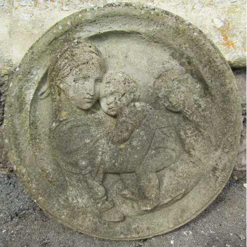 2061 - A weathered circular composition stone garden wall plaque with raised relief Madonna and child