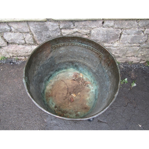 2081 - An antique copper with rolled rim and pop riveted seams, raised on later cast iron swept feet, 56cm ... 