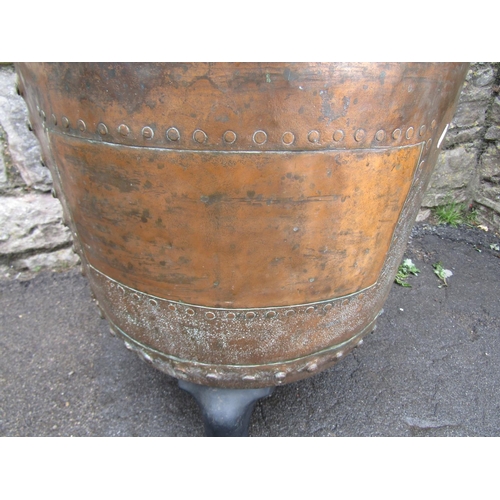 2081 - An antique copper with rolled rim and pop riveted seams, raised on later cast iron swept feet, 56cm ... 