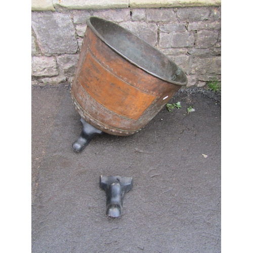 2081 - An antique copper with rolled rim and pop riveted seams, raised on later cast iron swept feet, 56cm ... 