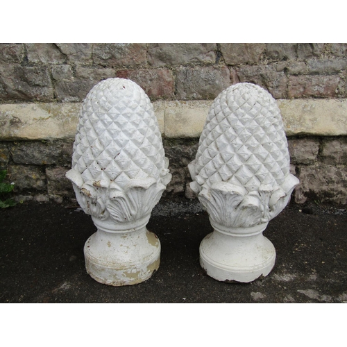 2085 - a pair of over painted and weathered decorative cast composition stone pineapple pier cap finials wi... 