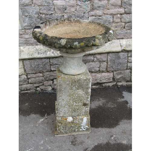 2086 - A weathered natural stone garden urn, the shallow circular carved bowl raised on a loose socle and s... 