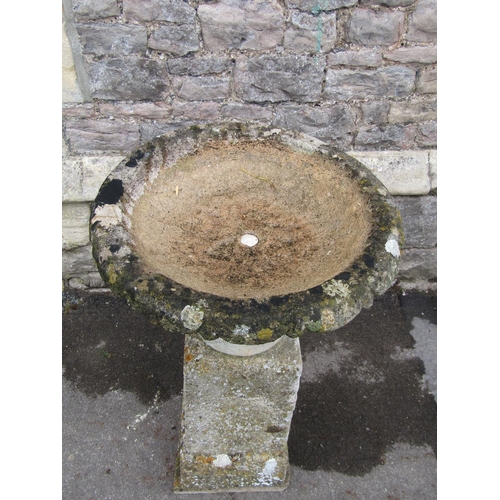 2086 - A weathered natural stone garden urn, the shallow circular carved bowl raised on a loose socle and s... 