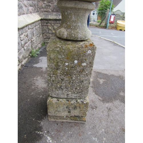 2086 - A weathered natural stone garden urn, the shallow circular carved bowl raised on a loose socle and s... 