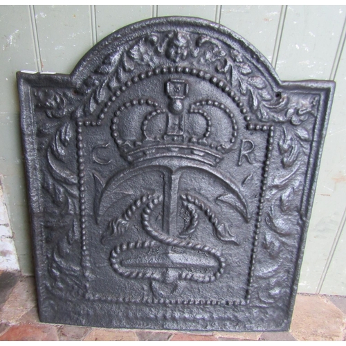 2094 - An old cast iron fire back with raised relief inverted anchor, crown, and further detail, 53cm wide ... 