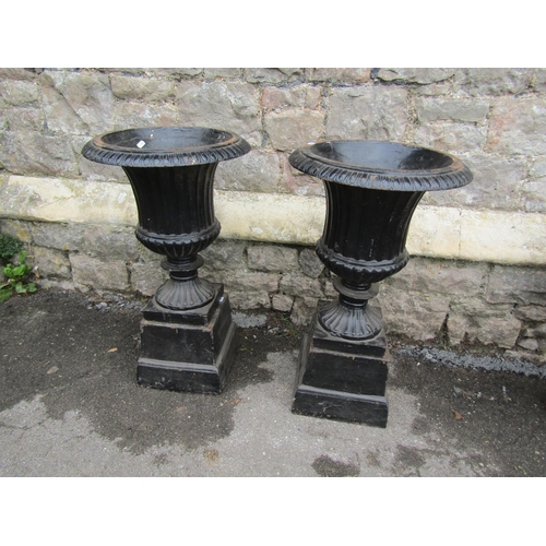 2102 - A pair of painted and weathered cast iron campana shaped garden urns, with flared rims, reeded and l... 