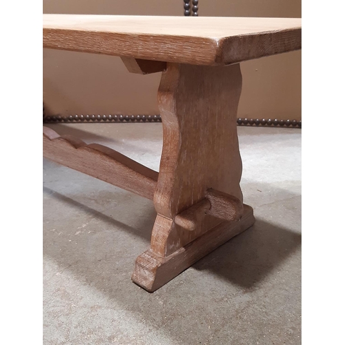 2120 - A low limed oak occasional table with rectangular top raised on shaped supports and sledge feet unit... 