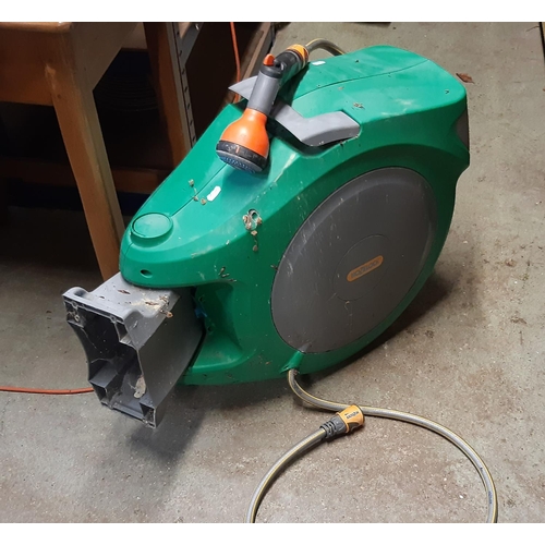 2130 - A Hozelock encased wall mounted hose reel together with a Scotts easy green rotary spreader model nu... 