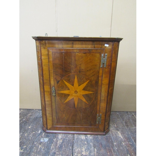 2601A - A Georgian figured walnut hanging corner cupboard, with central starburst detail, with H shaped bras... 