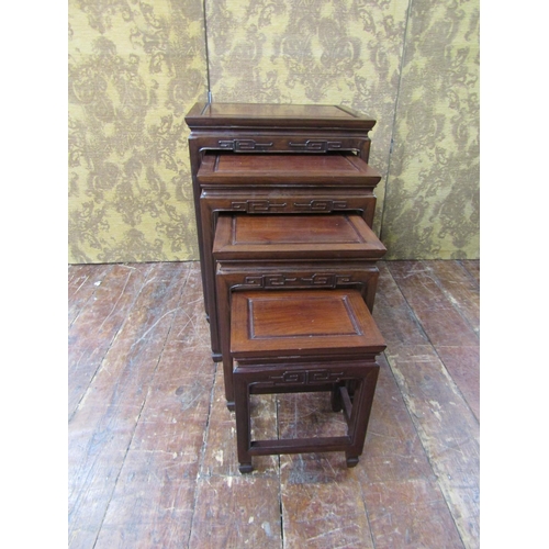 2607 - A graduated set of four Chinese hardwood occasional tables of rectangular form with carved borders, ... 